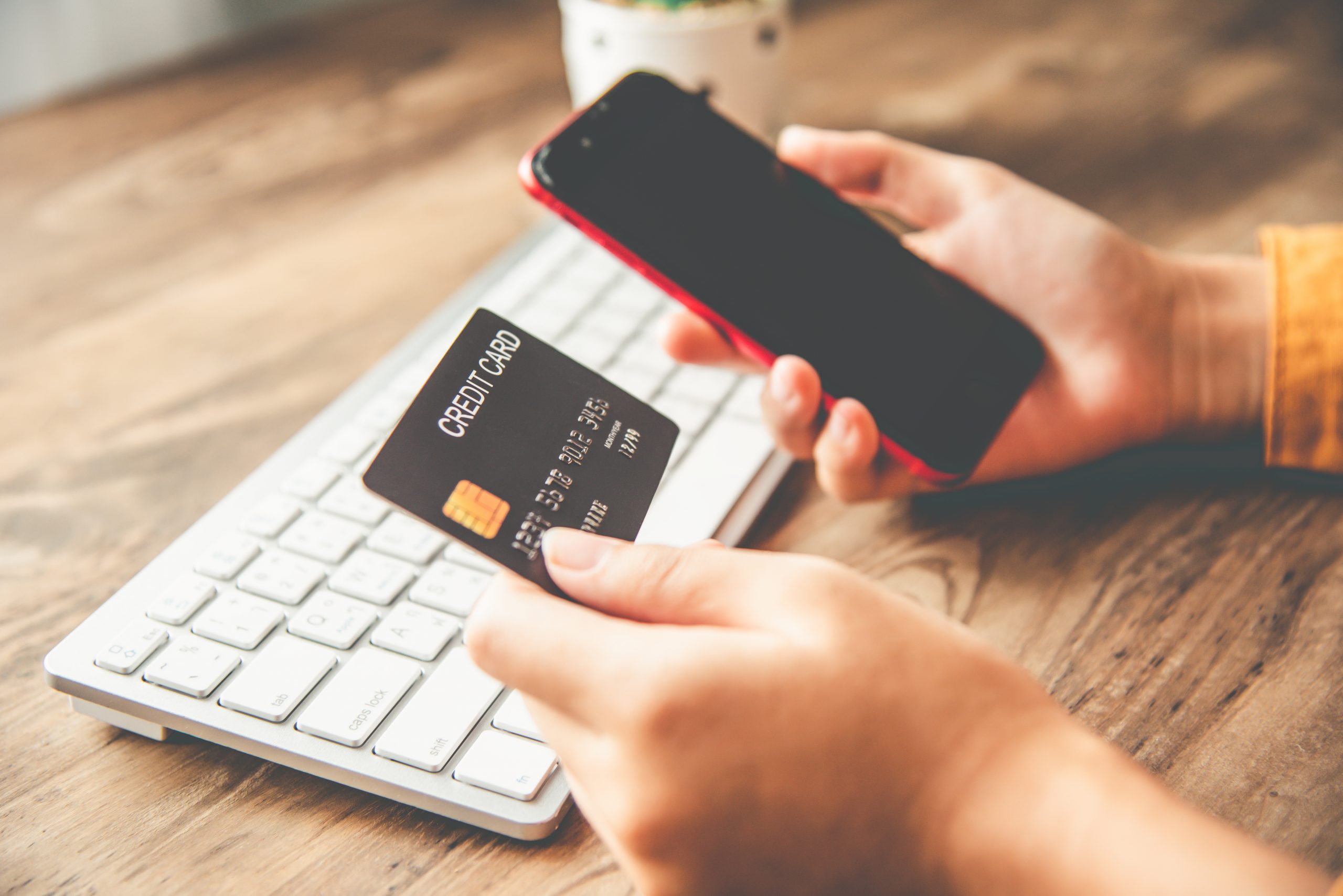 visuel d'une femme effectuant un paiement en ligne avec sa carte bancaire sur son téléphone