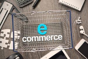 panier de magasin posé sur un bureau et dans lequel il est écrit "e commerce"