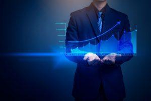 un manager devant un écran virtuel où apparait un graphique de stratégie commerciale