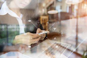 candidate devant son ordinateur avec son portable dans les mains en train de consulter les offres d'emploi dans le secteur du marketing
