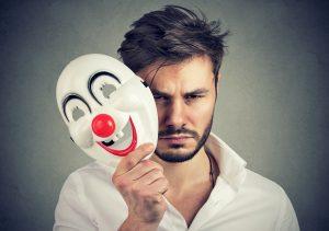 un homme pas content enlève un masque de clown