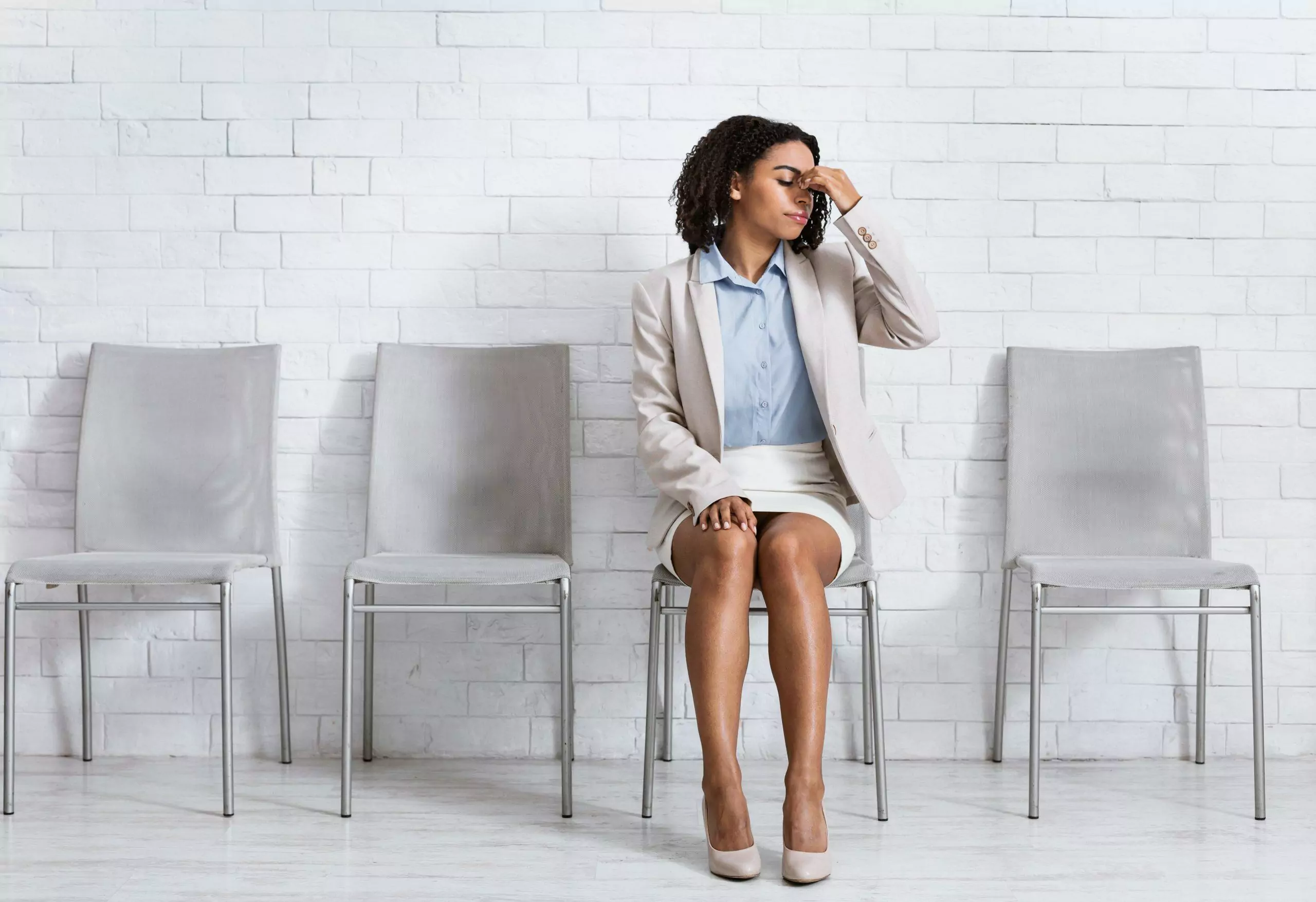 visuel d'une femme en train de réfléchir assise dans une salle d'attente vide