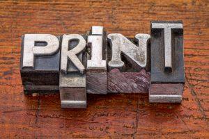 le mot print écrit sur des blocs métalliques illustrant l'article sur l'évolution de la communication print