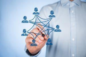 community manager qui dessine les liens entre différentes personnes sur un tableau digital